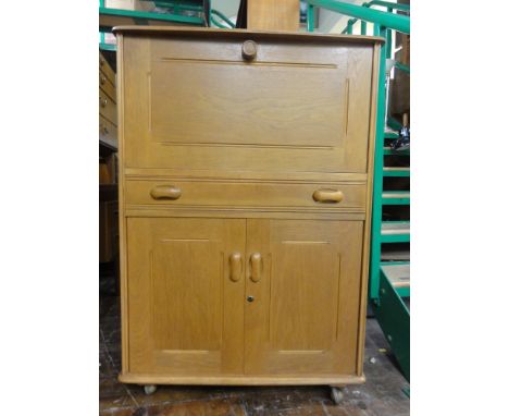 Ercol style light wood bureau fitted with a fall front over a single drawer and twin cupboard door