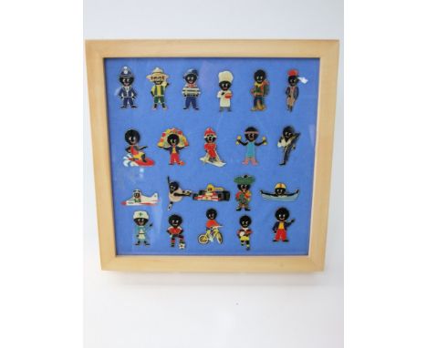 A framed collection of 21 Roberstons Golly enamel badges
