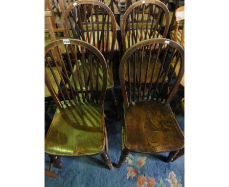 A set of four Windsor stained elm and beechwood hoop and stick back kitchen chairs raised on turned supports and stretchers
