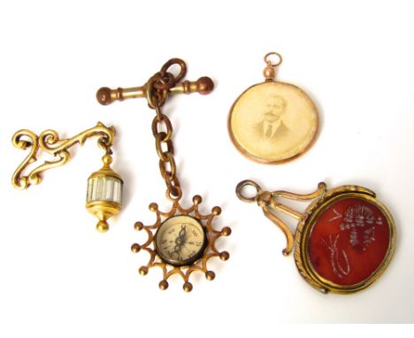A 9k gold circular open photo pendant together with a yellow metal carnelian swivel watch fob, a yellow metal watch fob with 
