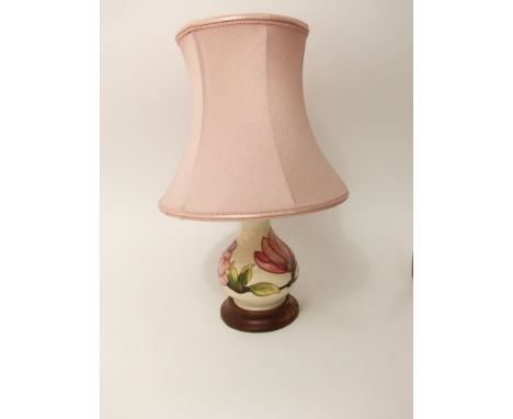 A Moorcroft cream ground lamp base with pink magnolia decoration and with pink waisted shade, 42cm tall approx overall (inclu