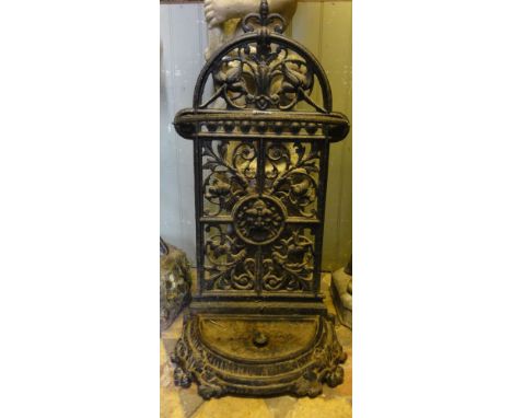 A Victorian cast iron stick stand of demi-lune form, the back with floral and other detail.