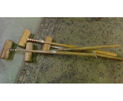 Four vintage croquet mallets.