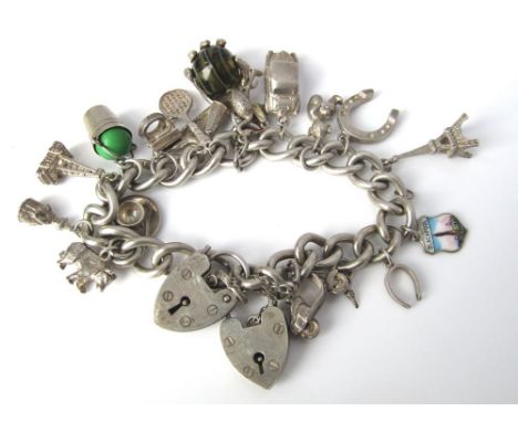 A sterling silver curb link charm bracelet set with numerous silver charms and some unmarked white metal examples 86g