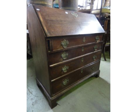 Georgian oak bureau the fall front enclosing a fitted interior over four long graduated drawers and bracket feet