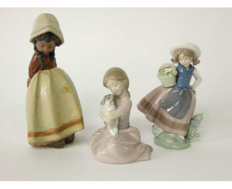 A Lladro Daisa model of a little girl in a bonnet with her hands crossed behind her back, with matt brown glazed finish, toge