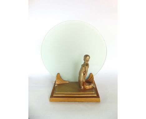 Art deco figural table lamp in the form of a nude lady kneeling in front of circular opaque glass screen upon a stepped squar