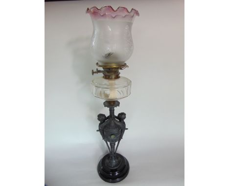 Impressive cast spelter oil lamp fitted with maiden heads with clear faceted glass reservoir and etched glass shade