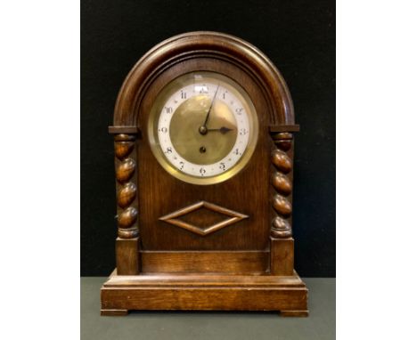 An early 20th century oak mantel clock, Arabic numerals,, the arched case with turned columns, 38cm high, c.1930 