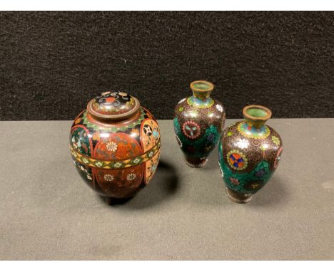 A Japanese cloisonné enamel urn, the six shield panels decorated with traditional motifs inc lanterns, flowers, butterflies ,