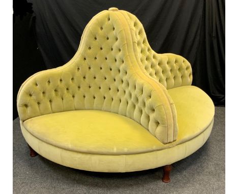 A large Victorian style conversation seat, the circular four sided button back body upholstered in green lined fabric, plain 