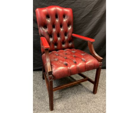 A mid 20th century button-back open arm office chair, sang de boeuf leather, mahogany arms and legs, 102cm tall 