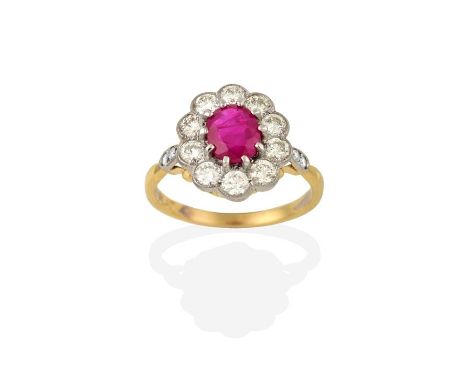 A Ruby and Diamond Cluster Ring, the oval cut ruby within a border of round brilliant cut diamonds, in white claw and millegr