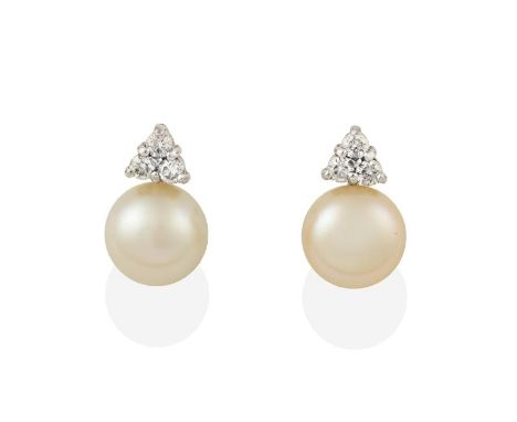 A Pair of 18 Carat White Gold Cultured Pearl and Diamond Earrings, the cultured pearl surmounted by a trio of round brilliant