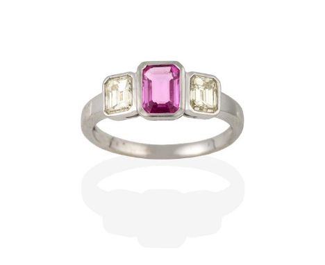 A Pink Sapphire and Diamond Three Stone Ring, the emerald-cut pink sapphire flanked by step cut diamonds, in white rubbed ove