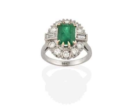 An Emerald and Diamond Cluster Ring, the emerald-cut emerald within a border of round brilliant cut diamonds, with baguette c