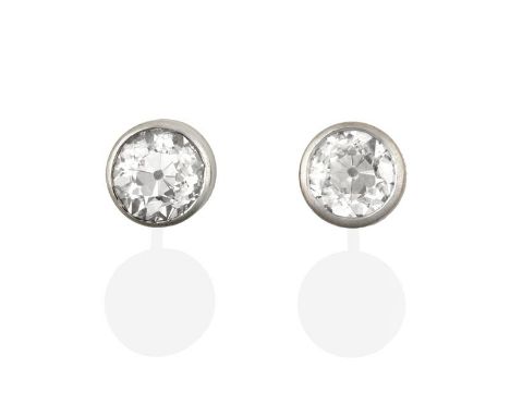 A Pair of 18 Carat White Gold Diamond Solitaire Earrings, the round brilliant cut diamonds in rubbed over settings, total est