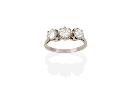 A Diamond Three Stone Ring, the round brilliant cut diamonds in white claw settings, to a tapered shoulder plain polished sha