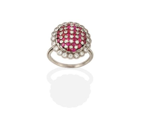 A Ruby and Diamond Ring, the central oval dome formed of rows of round cut rubies alternating with round brilliant cut diamon