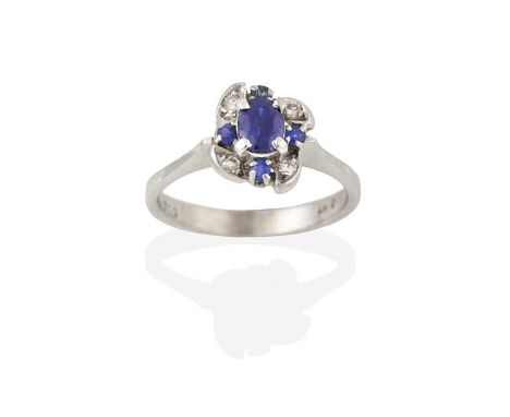 A Sapphire and Diamond Cluster Ring, the oval cut sapphire within an undulating border of eight-cut diamonds alternating with