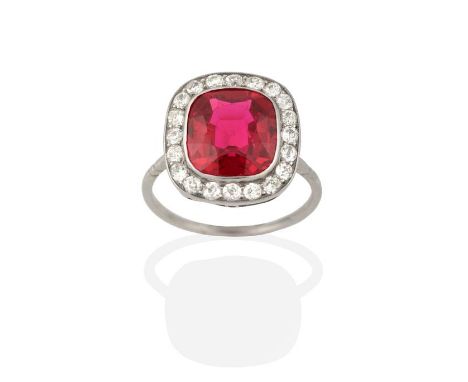 A Synthetic Ruby and Diamond Cluster Ring, the cushion cut synthetic ruby in a white rubbed over setting, within a border of 