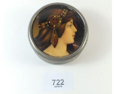 A metal trinket box with printed and painted head of pre-raphaelite woman 7cm diameter
