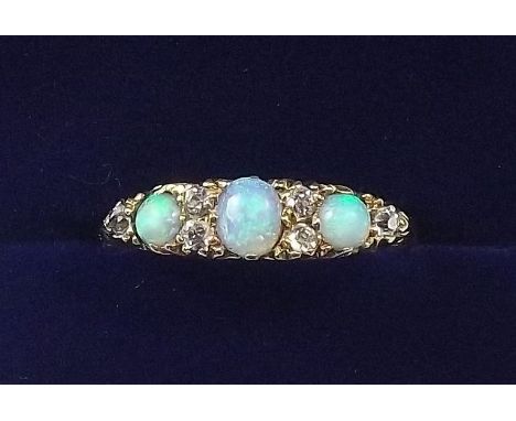 An 18 carat gold ring set three opals interspersed with six diamonds - diamond total weight approx .3cts - size O with insura