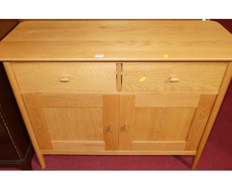 A contemporary Ercol blond elm round cornered two-door side cupboard, having twin upper drawers, width 109cm