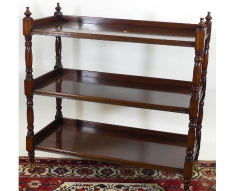 A mahogany three-tier buffet whatnot, raised on square cut and turned supports to polished brass cup castors, width 102cm