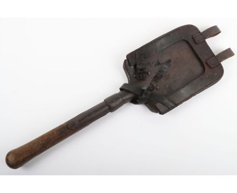 WW1 German Entrenching Tool, with a heavily pitted steel head, wooden haft and a un-marked leather cradle / harness with belt