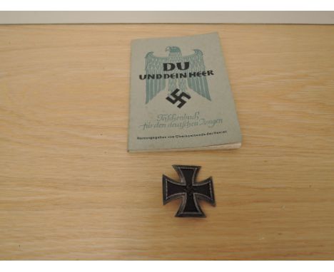 A 1939 German Iron Cross Badge and a copy of Du Und Dein Heer Taschenbuch Für Den Deutschen Jungen, You and Your Army Paperba