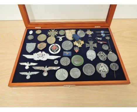 A display case containing 40+ German Badges, Medals and Stick Pins including Crimea 1941/1942 Shield, War Merit 1939 with cro