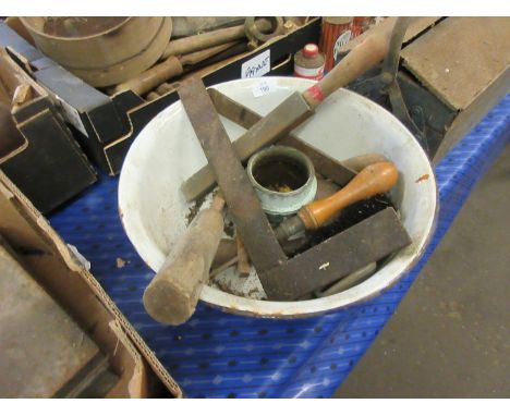 Vintage enamel mixing bowl containing assorted tools