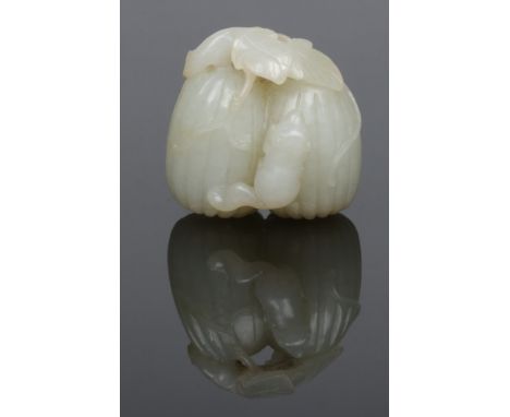 A Chinese Qing dynasty pale celadon jade carving, formed as a pair of melons with a squirrel clambering across their surface,