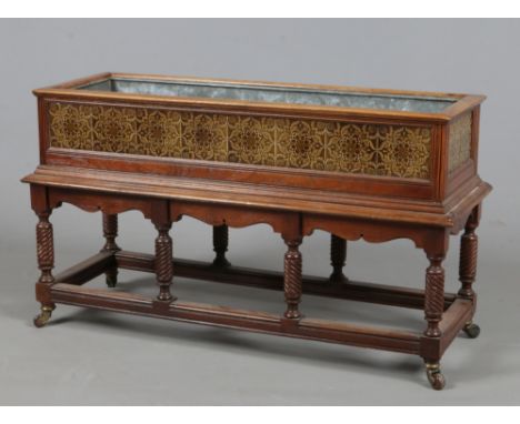 A mahogany Arts &amp; Crafts planter with majolica tiles, metal liner and raised on twist carved supports, 98cm x 37cm