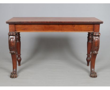 An early 19th century Irish mahogany console table. With carved double scrolling supports terminating on paw feet, 145cm wide