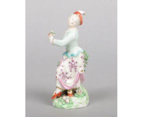 A Derby&nbsp;Commedia dell'arte figure of Columbine, Harlequins companion. Modelled in a twisted pose holding a flower, leani