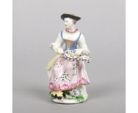 A Bow&nbsp;Commedia dell'arte&nbsp;figure of Columbine seated playing a hurdy gurdy. Painted in polychrome enamels, her dress