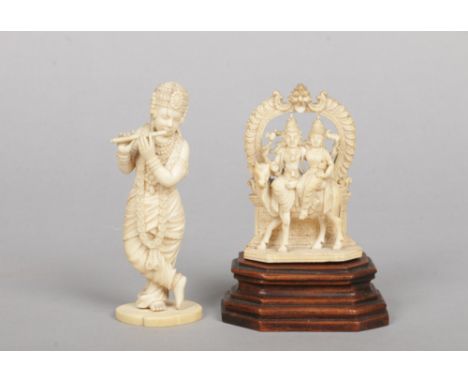 Two 19th century Indian ivory carvings. One formed as a figure playing a flute, the other a pair of figures riding an ox unde