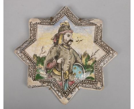 An antique eastern tile of star form. Painted in coloured enamels with a huntsman, 29cm wide.&nbsp;