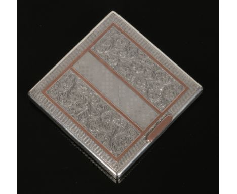 A silver powder compact by The Goldsmiths and Silversmiths Co. Engraved with scrolls and having rose gold embellishments. Ass