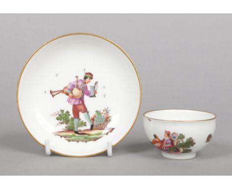 A Meissen teabowl and saucer. With gilt rims and painted in coloured enamels with figures at various pursuits, the saucer wit
