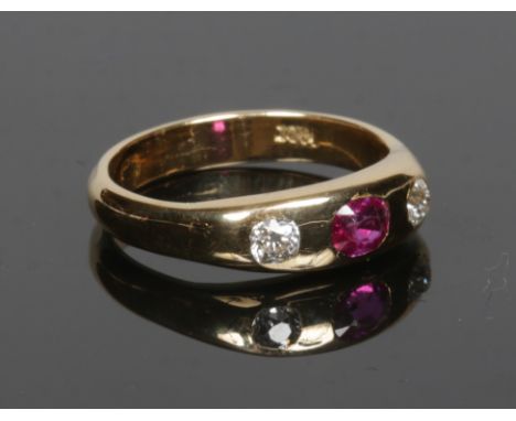 An 18 carat gold ruby and diamond ring with rub over set stones. Size N.