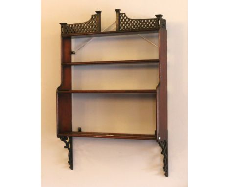 A 19th century mahogany four tier wall shelf with open fret carved pediment, 78cm.