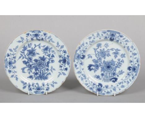 Two 18th century English delft blue and white plates painted with flowers, 22cm diameter.