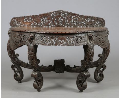 A 19th century Anglo Indian hardwood demi lune console table. Adorned with pierced foliate carvings with birds and lion masks