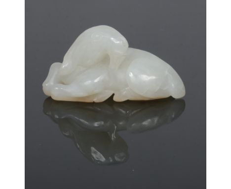 A late 19th century Chinese pale celadon jade carving of a recumbent goat, 5cm.