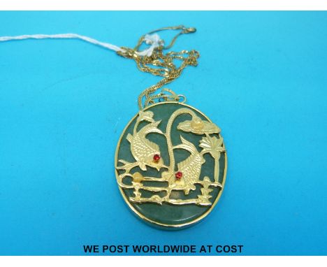 A yellow metal pendant set with a jade plaque on 9ct gold chain 