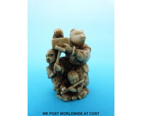 A Japanese Meiji period signed carved ivory netsuke of three masked figures in a theatrical scene (4.5cm tall)