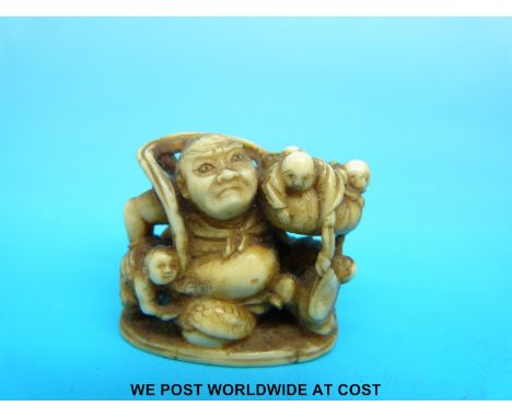 A Japanese Meiji period carved ivory netsuke of a giant with figures in his basket (4.4cm tall)